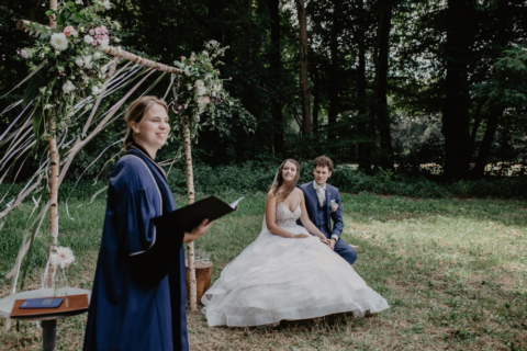 Charlotte Waardenburg spreekt en een bruidspaar kijkt toe
