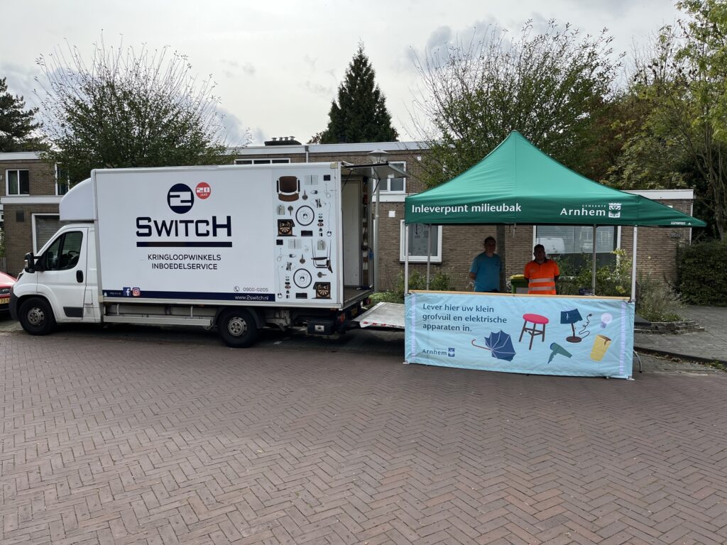 foto van de Milieubak: een vrachtwagen van 2Switch met een tent ervoor als inleverpunt